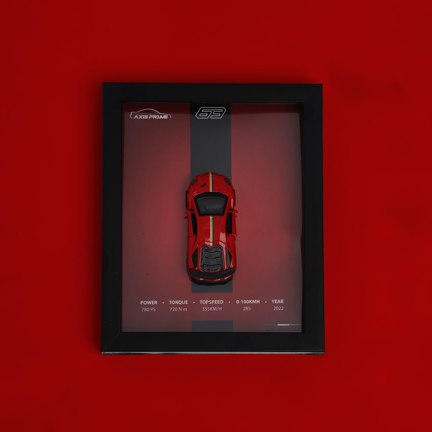 Red toy car in a black frame on a red background