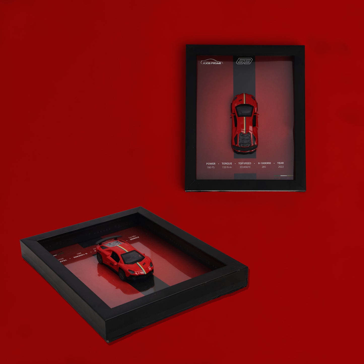 Two framed models of red sports cars on a red background