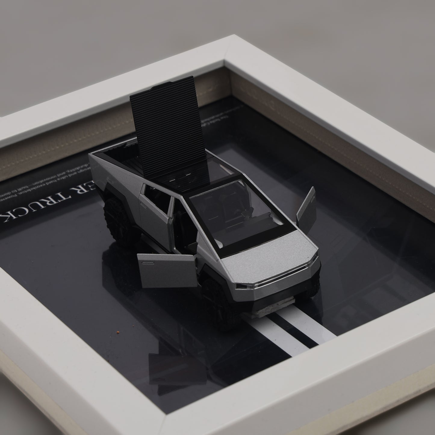 Model of a pickup truck on a reflective surface with a gray background
