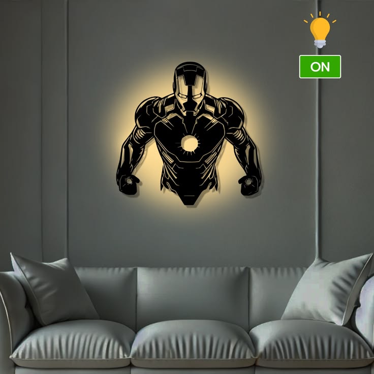 Black Iron Man LED wall lamp with warm golden backlighting above a grey sofa in a modern living room