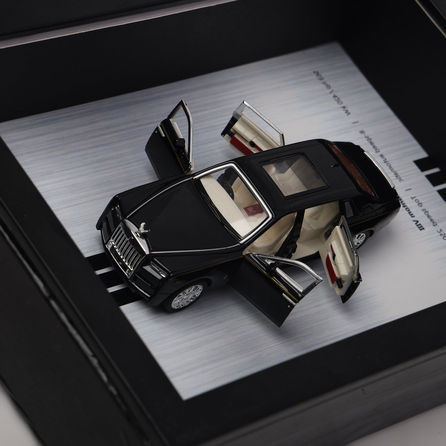 Model car with open doors on a metallic surface