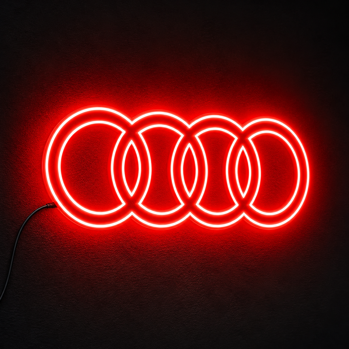 Audi four-ring logo LED wall sign glowing blue against a dark brick wall