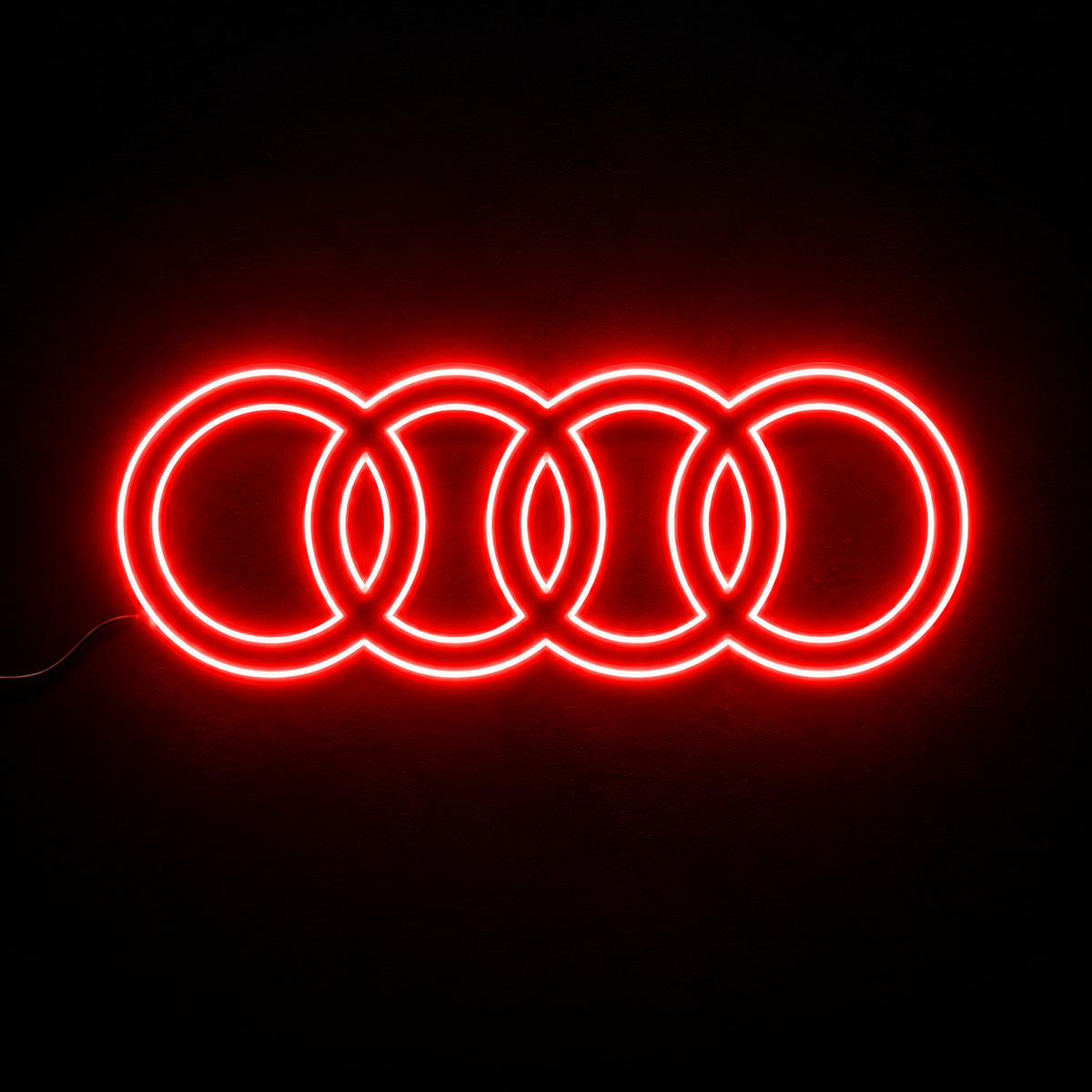 Audi four-ring logo LED wall sign glowing blue against a dark brick wall