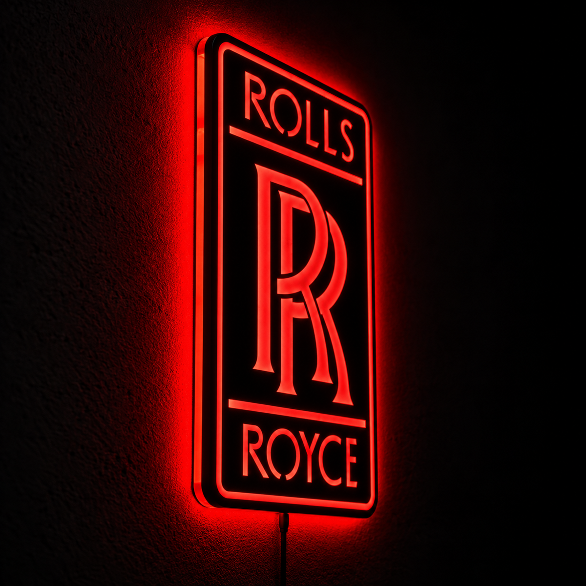 Rolls-Royce logo LED wall sign with golden illumination on a black rectangular plaque against a concrete wall
