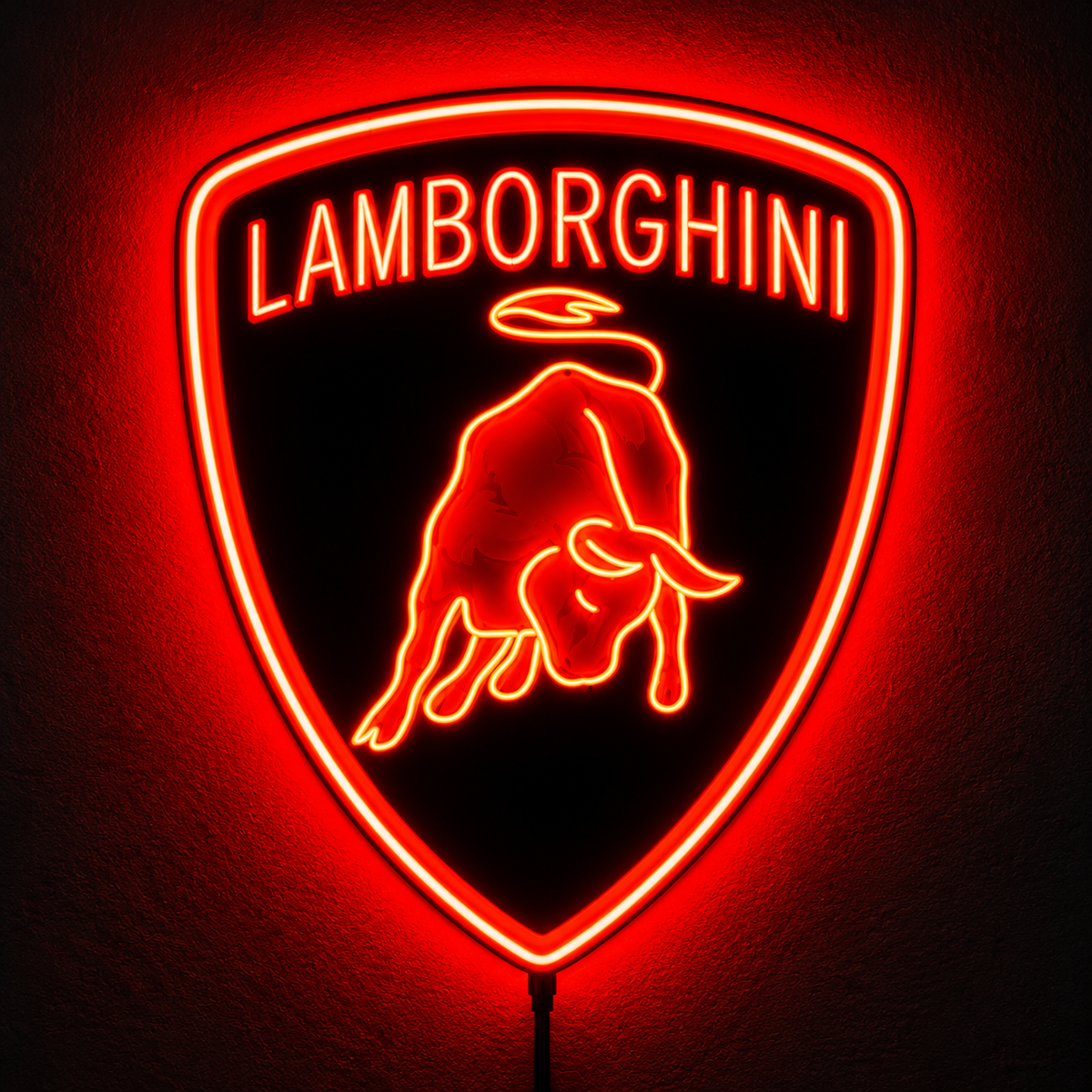 Lamborghini shield logo LED wall sign glowing yellow above a sofa in a modern living room