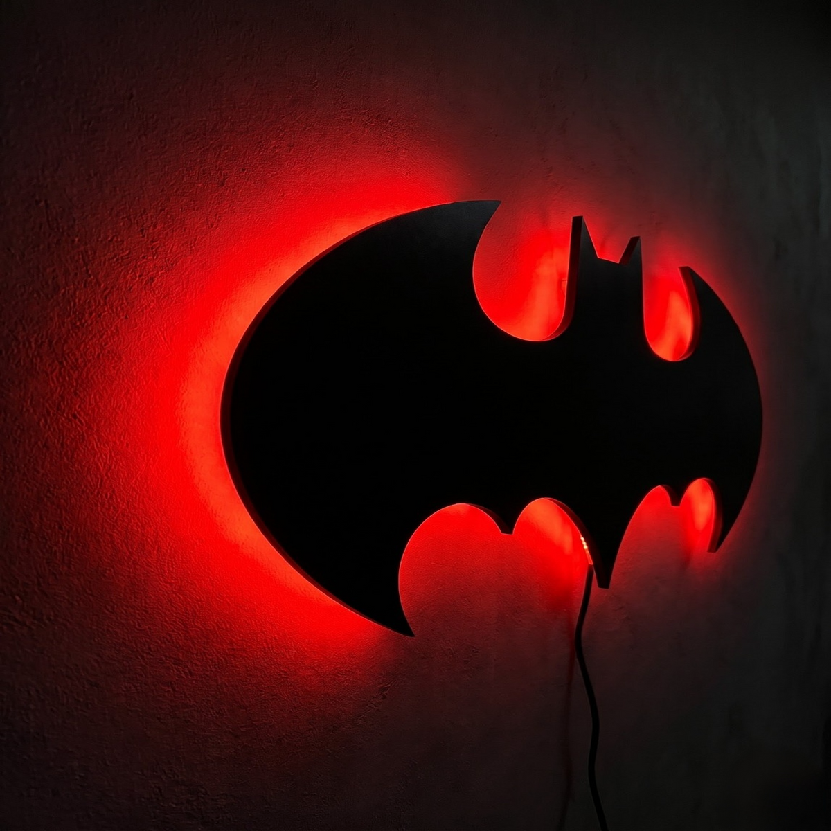 Premium Batman LED wall lamp with warm yellow glowing emblem on dark wall