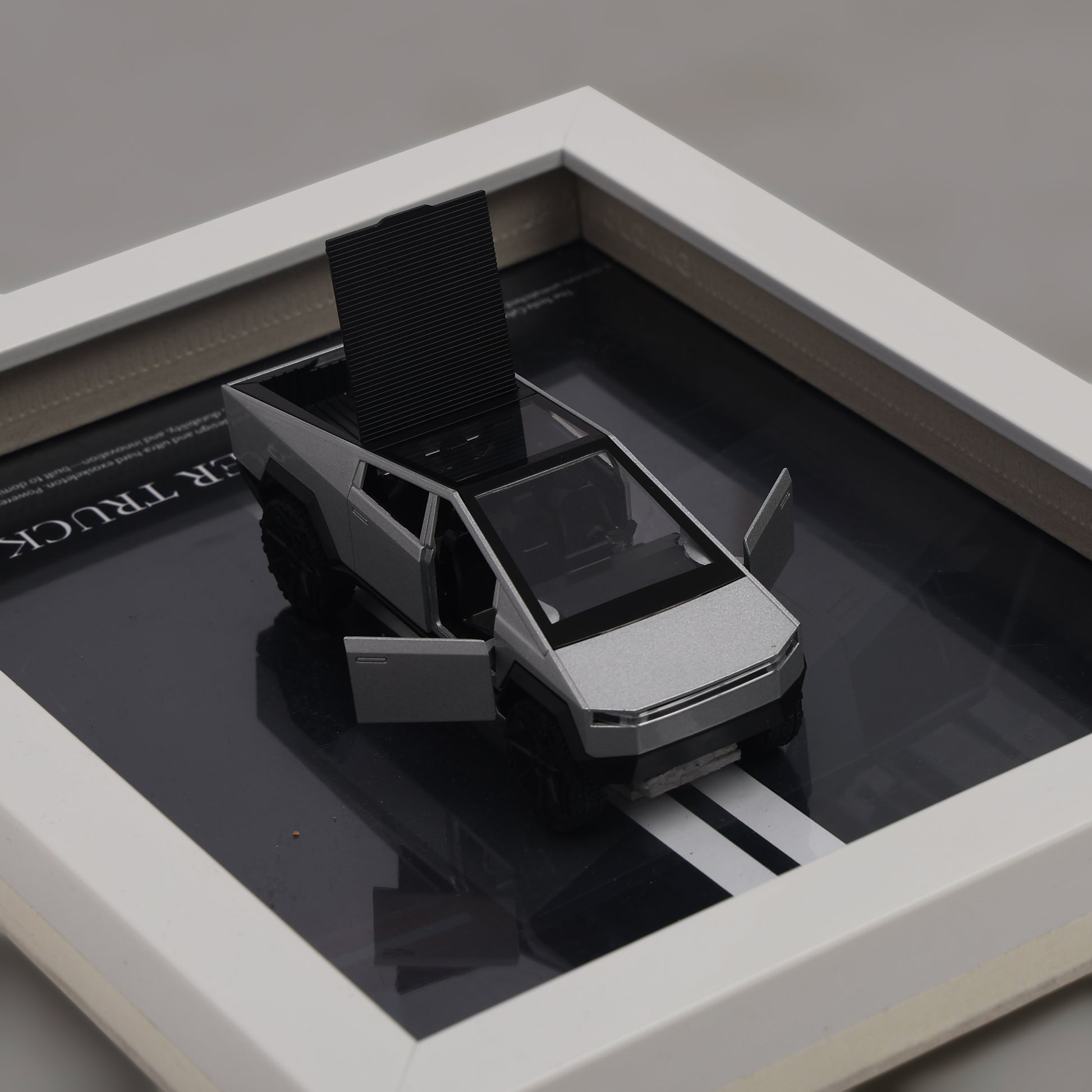 Model of a pickup truck on a reflective surface with a gray background