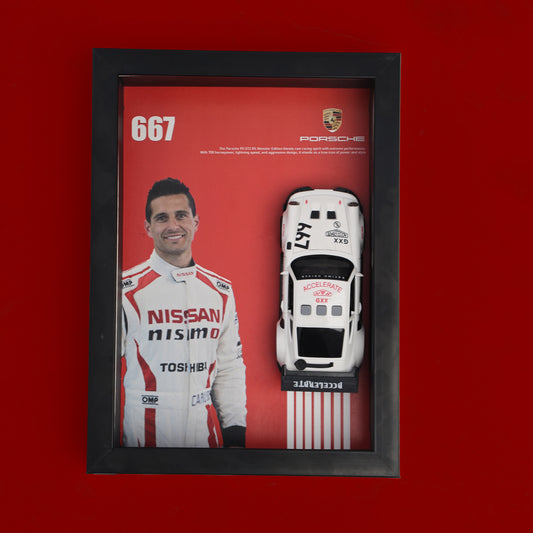 Framed display of a Nissan driver and model car on a red background