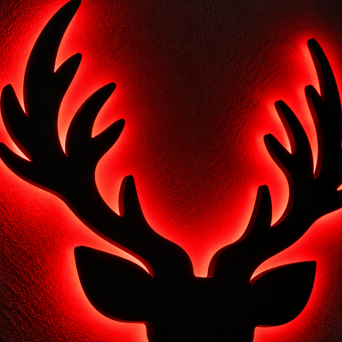 Deer head LED wall lamp with black antler silhouette and warm yellow glowing light against a blue background
