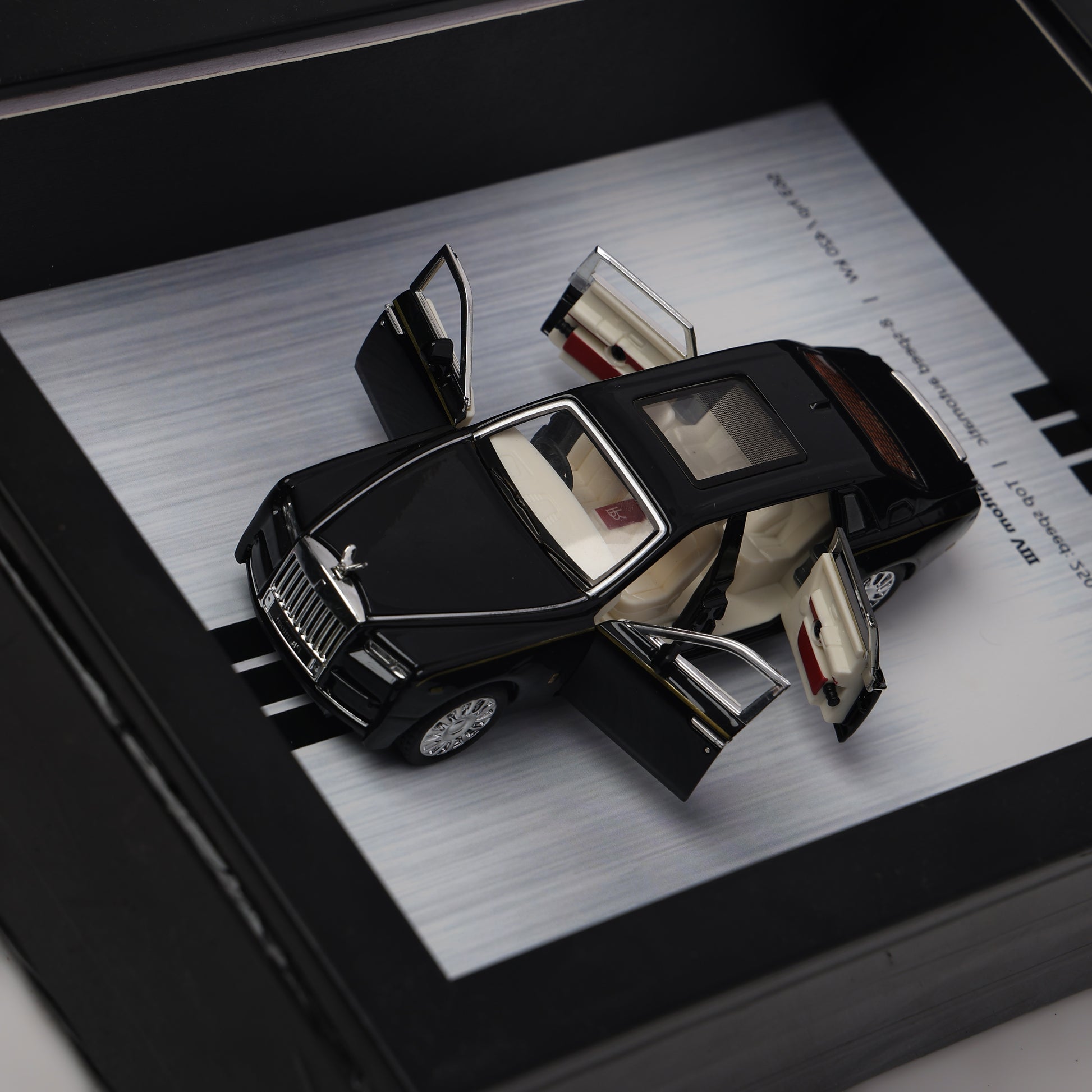 Model car with open doors on a metallic surface