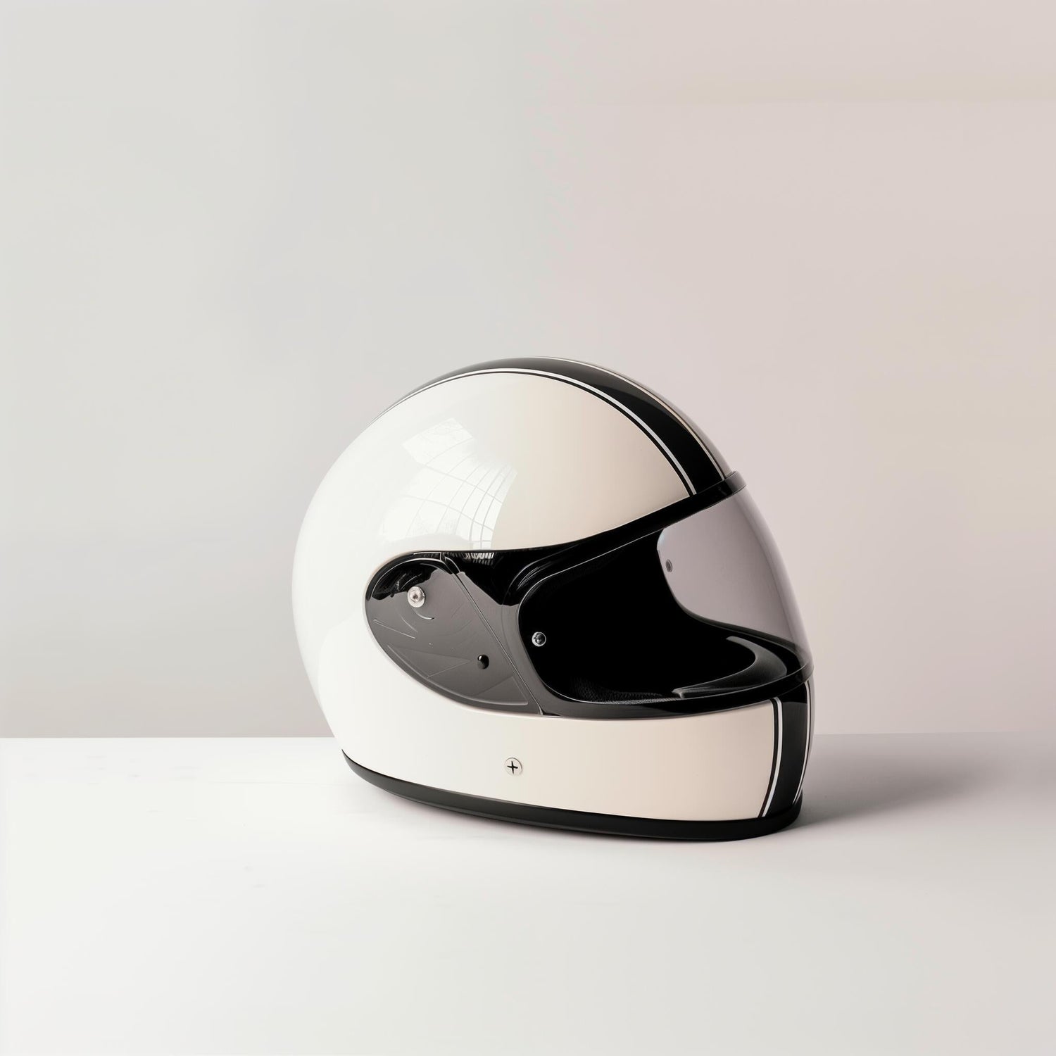 A white motorcycle helmet with a black visor sits on a white surface against a light gray background.